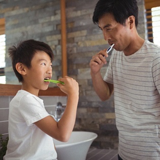 Padre e hijo cepillándose los dientes juntos