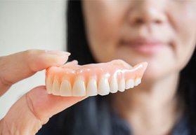 Woman holding dentures