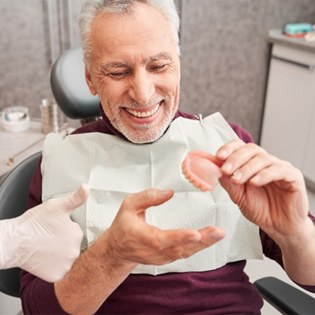A dentist showing denture to her male patient