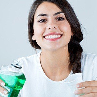 woman using mouthwash