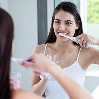 woman using electric toothbrush