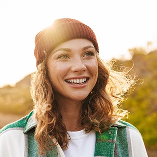 a smiling person walking outdoors