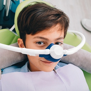 A young boy with a nitrous oxide mask on 