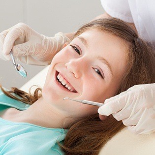 young girl smiling in exam chair
