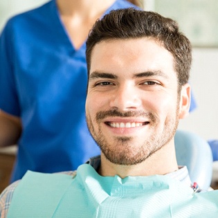 A young man smiling after receiving a dental bridge in Bergenfield