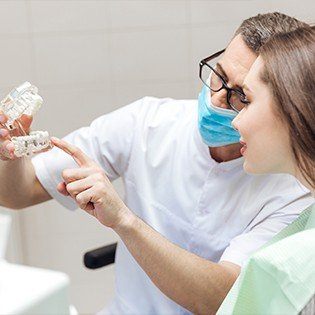 dentist showing plastic denture