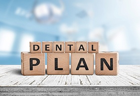 Dental plan written on wooden blocks, resting on tabletop