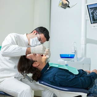 A male patient having his mouth examined by a dentist