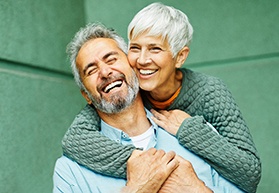 Couple smiling with dental implants in Bergenfield