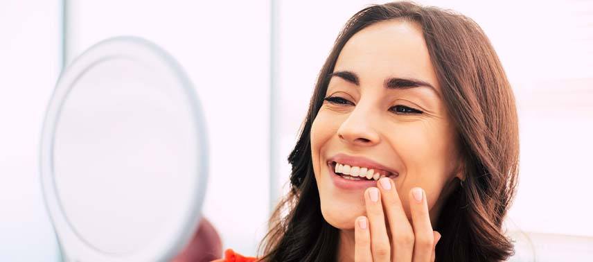 Woman admiring her new dental implants in Bergenfield