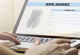 Dental insurance info on laptop for the cost of dental implants in Bergenfield