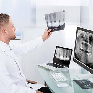 Bergenfield implant dentist looking at patient X-rays