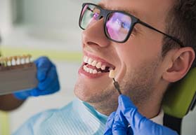 man smiles while getting dental implants in Bergenfield