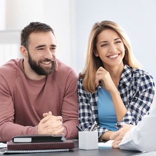 A couple speaking with the dentist