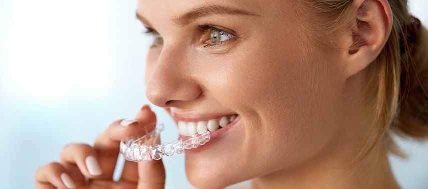 woman putting in invisalign clear tray
