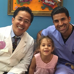 Dr. Tong and Dr. Mendia with child patient