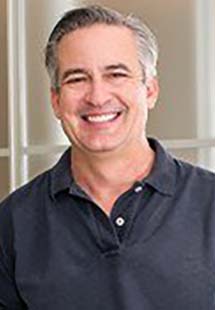 a man in grey shirt smiling near Dumont