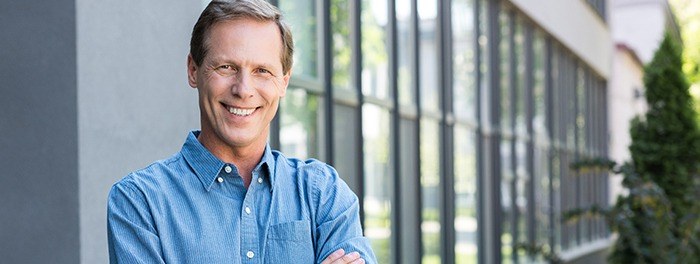 man smiling with arms crossed