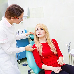 A female patient listening to her dentist explain why she needs a root canal