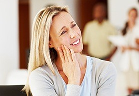 woman holding jaw in pain