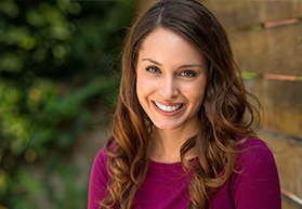 woman smiling by brick wall