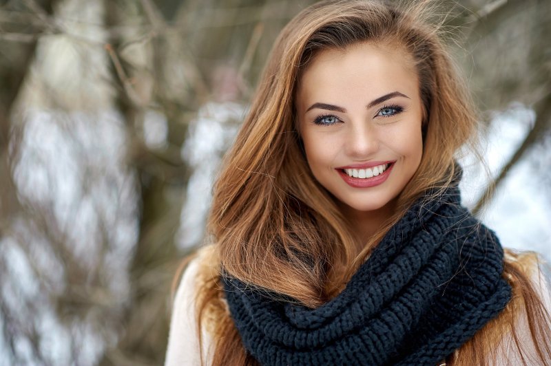 woman smiling while outside in cold weather