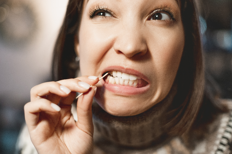 Patient with good dental health using a toothpick